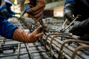 A group of builders is busy constructing a metal structure.