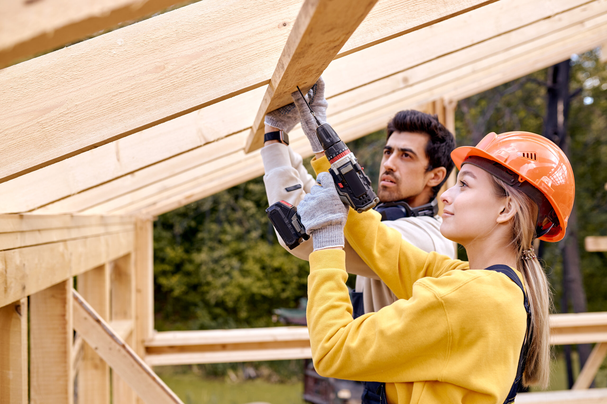 contractors in work clothes using electric drill. Home renovation, sustainable living